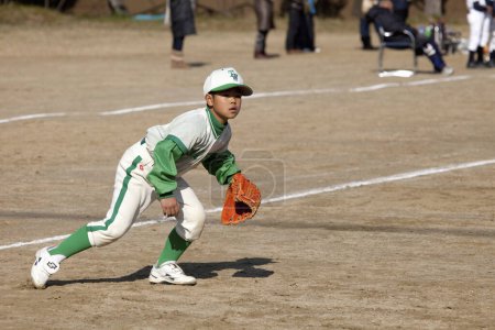Photo for Japanese boy playing baseball on field - Royalty Free Image