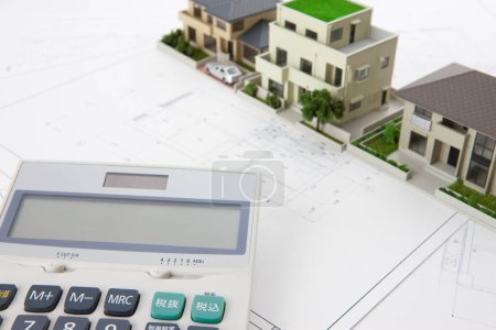 Téléchargez les photos : Models of houses with calculator and blueprints on table. real estate concept - en image libre de droit