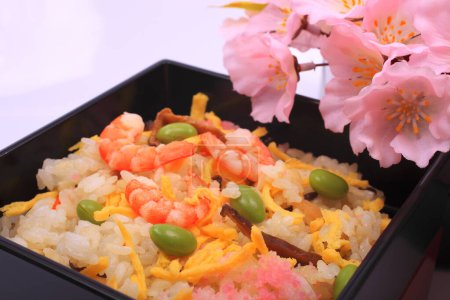 Foto de Cocina japonesa. delicioso arroz con gambas y verduras y flores de primavera rosa sobre fondo claro - Imagen libre de derechos