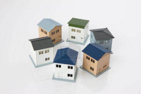 Téléchargez les photos : Petits modèles de maisons sur fond blanc, concept hypothécaire - en image libre de droit