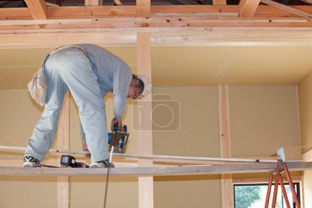 Foto de Trabajador de la construcción instalando marco de madera en nuevo hogar - Imagen libre de derechos