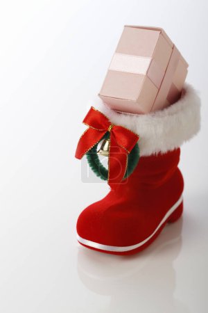 Téléchargez les photos : Chaussure rouge de Noël avec cadeau isolé sur fond. - en image libre de droit