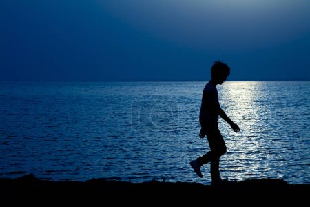 Photo for Silhouette of a boy on the beach - Royalty Free Image