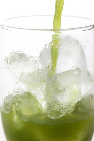 Téléchargez les photos : Vue rapprochée du verre de thé vert matcha glacé sur fond clair - en image libre de droit