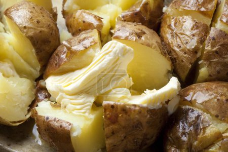 Téléchargez les photos : Vue rapprochée de délicieuses pommes de terre au four avec beurre et épices - en image libre de droit