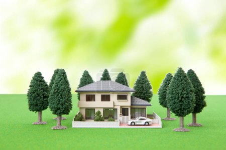 Photo for Miniature house model and green trees on grassy meadow. real estate concept - Royalty Free Image