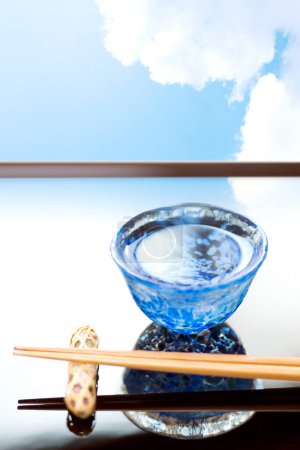 Foto de Vista de cerca de los palillos colocados sobre la base de reposo y la taza de sake - Imagen libre de derechos