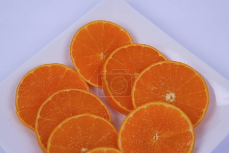 Téléchargez les photos : Assiette d'oranges tranchées isolées sur fond blanc - en image libre de droit