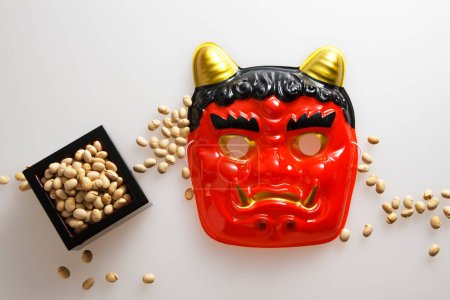 devil mask and beans for mame-maki (bean-throwing) on table. Image of Setsubun, japanese traditional event. Setsubun means the day between two seasons. People throw beans to expel evil spirits and bring good luck