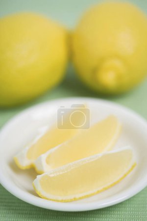 Photo for Close up of a lemon and slices in a white plate - Royalty Free Image