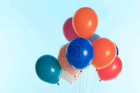Photo for Colorful helium balloons against blue background - Royalty Free Image