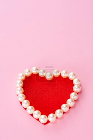 Foto de Corazón rojo de perlas sobre fondo rosa - Imagen libre de derechos