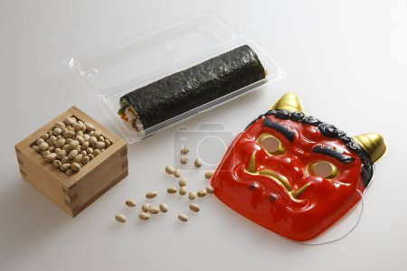 Rouleau Eho-maki, haricots pour mame-maki (lancer de haricots), et masque de démon sur la table. Image de Setsubun