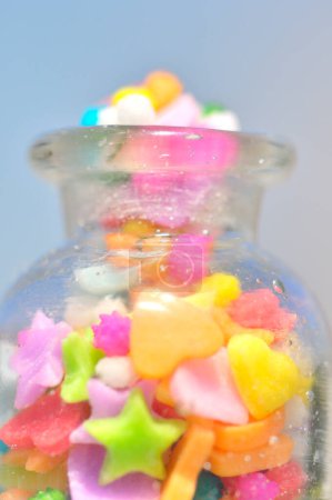 Téléchargez les photos : Vue rapprochée du bocal en verre et des bonbons colorés sur fond clair - en image libre de droit