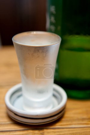 Sake  glass and bottle on background, close up