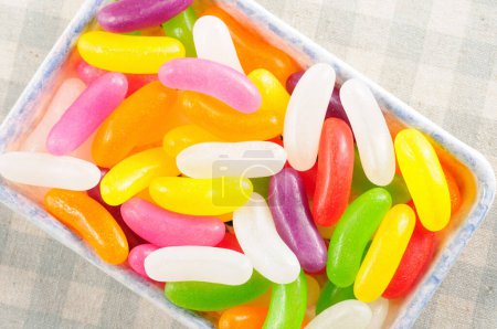 Téléchargez les photos : Bonbons colorés dans un bol sur fond clair - en image libre de droit