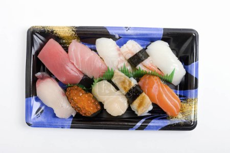 Téléchargez les photos : Une assiette de sushi avec une variété de garnitures - en image libre de droit