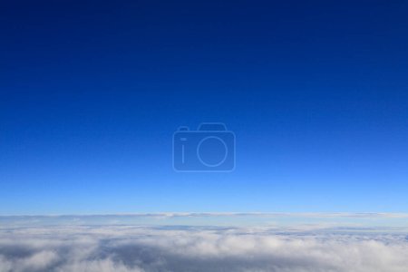 Téléchargez les photos : Nuages au-dessus du ciel bleu depuis la fenêtre de l'avion - en image libre de droit
