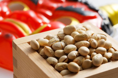 Photo for Devil mask and beans for mame-maki (bean-throwing) on table. Image of Setsubun, japanese traditional event. Setsubun means the day between two seasons. People throw beans to expel evil spirits and bring good luck - Royalty Free Image