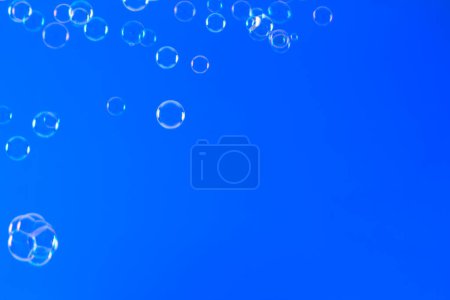 Téléchargez les photos : Bulles de savon sur fond bleu, gros plan - en image libre de droit