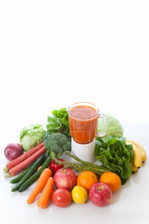 Foto de Zumo de frutas y verduras frescas en licuadora con frutas y verduras orgánicas maduras sobre fondo blanco - Imagen libre de derechos