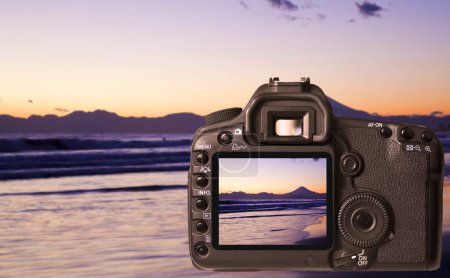 Photo for Digital camera on the beach with blurred sunset background - Royalty Free Image