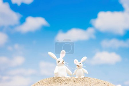 Photo for Cute toy rabbits at beach on summer background - Royalty Free Image