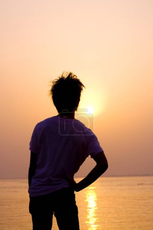 Foto de Silueta del hombre con puesta de sol en el fondo del mar - Imagen libre de derechos
