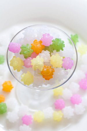 Foto de Vista de cerca de deliciosos dulces caramelos de colores en vidrio sobre fondo blanco - Imagen libre de derechos