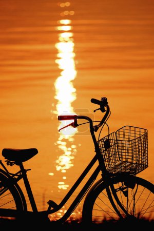 Téléchargez les photos : Un vélo garé à côté d'un plan d'eau - en image libre de droit