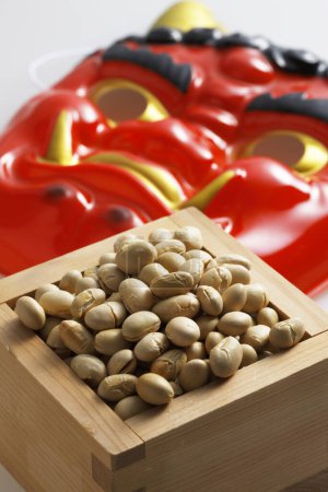 devil mask and beans for mame-maki (bean-throwing) on table. Image of Setsubun, japanese traditional event. Setsubun means the day between two seasons. People throw beans to expel evil spirits and bring good luck