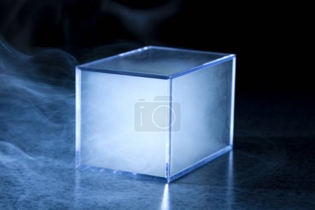Téléchargez les photos : Cube en verre vide avec fumée sur fond noir. espace pour le texte - en image libre de droit