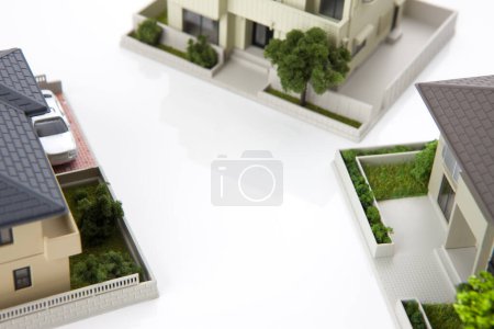 Téléchargez les photos : Petits modèles de maisons sur fond blanc, concept hypothécaire - en image libre de droit
