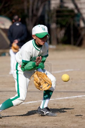 Téléchargez les photos : Japonais garçon jouer baseball sur le terrain - en image libre de droit