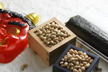 Photo for Eho-maki roll, beans for mame-maki (bean-throwing), and demon mask on table. Image of Setsubun - Royalty Free Image