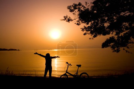 Photo for Silhouette of a man with a bicycle in a sunset - Royalty Free Image