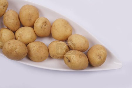 Foto de Placa de patatas crudas sobre fondo blanco - Imagen libre de derechos