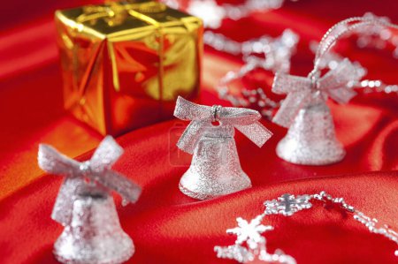 Foto de Campanas de plata en la mesa de Navidad roja - Imagen libre de derechos