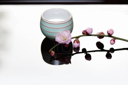 Téléchargez les photos : Tasse de thé avec branche de fleurs roses - en image libre de droit