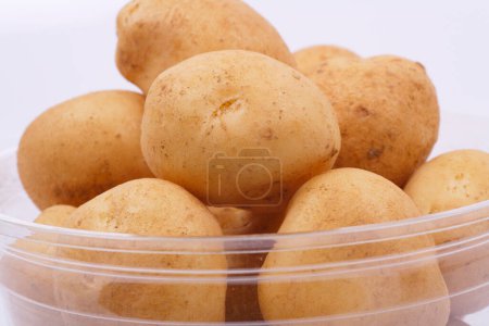 Foto de Tazón de patatas crudas sobre fondo blanco - Imagen libre de derechos