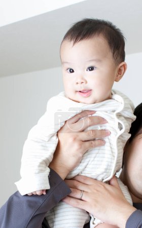 Photo for Happy Japanese boy on mothers hands, Woman holding little son on hands, closeup - Royalty Free Image