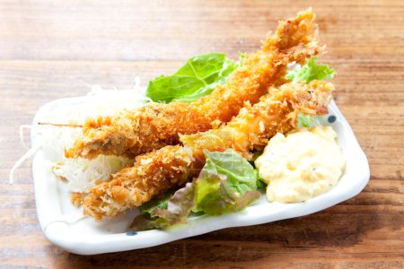 Téléchargez les photos : Une assiette de nourriture avec une salade et des crevettes frites - en image libre de droit