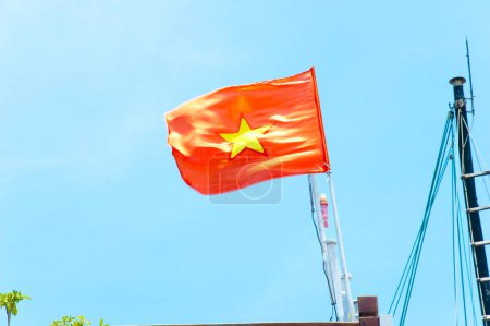 Foto de Ondeando la bandera roja de Vietnam contra el cielo azul - Imagen libre de derechos