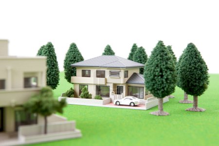 Foto de Miniature houses models and green trees on grassy meadow. - Imagen libre de derechos