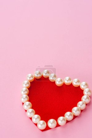 Foto de Corazón rojo de perlas sobre fondo rosa - Imagen libre de derechos