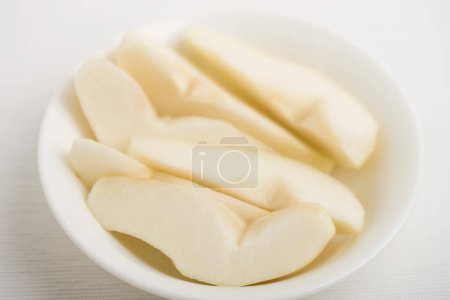 Photo for Fresh ripe pear  slices on white dish - Royalty Free Image