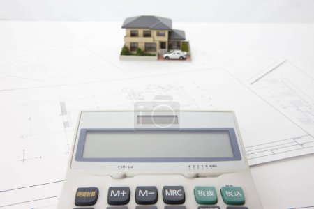 Téléchargez les photos : Model of house with calculator and blueprints on table. real estate concept - en image libre de droit