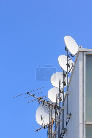 Téléchargez les photos : Antennes paraboliques sur le toit et ciel bleu - en image libre de droit