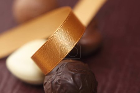 Téléchargez les photos : Gros plan d'un délicieux chocolat et du ruban adhésif sur une table en bois - en image libre de droit