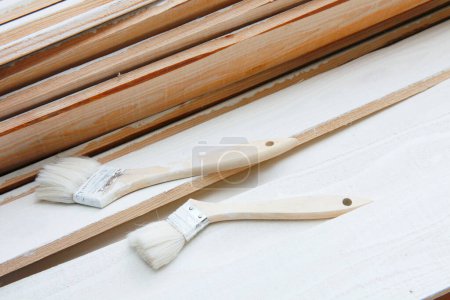 Photo for Paint brushes and wooden boards with white paint - Royalty Free Image